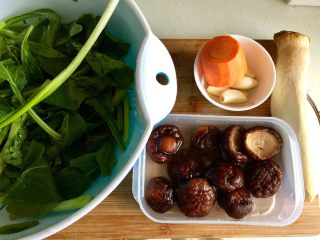 2、双菇烩,干香菇洗去浮灰提前用温水泡发,杏鲍菇清洗,胡萝卜削皮清洗,菜心择好掰适当大小均匀段清洗控水,蒜瓣去皮与小葱清洗备用