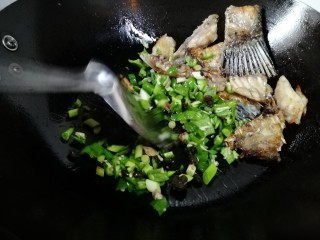 8、豆豉鱼,火关小，放入青椒豆豉，翻炒片刻