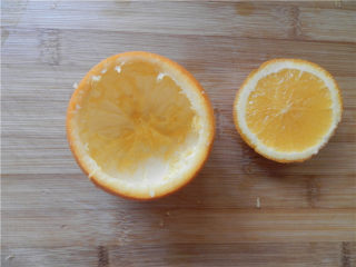 3、国橙蒸枸杞蛋,用一个不锈钢勺子，把橙子里面的果肉给挖出来，留下完整的球形橙子皮容器及其小盖子。