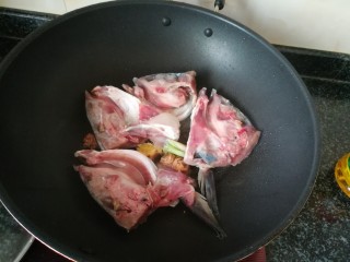 4、一学就会的,酸爽可口,驱寒暖胃的酸菜鱼头汤,炒出香味后加入处理干净的鱼头稍微翻炒后,加入几滴蒸鱼豉油,煎一会儿。