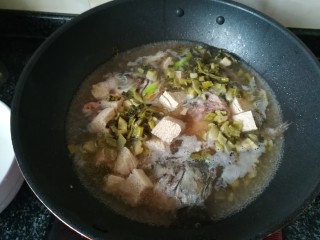 5、一学就会的,酸爽可口,驱寒暖胃的酸菜鱼头汤,煮个2分钟后,加入酸菜和豆腐,继续焖煮。