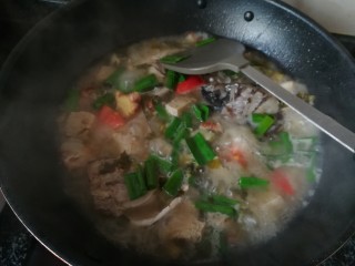 8、一学就会的,酸爽可口,驱寒暖胃的酸菜鱼头汤,最后加入蒜叶,稍加翻动后,加入盐巴和味精,即可起锅。