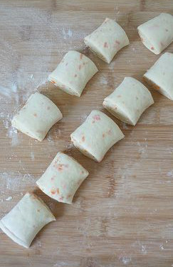 9、【胡萝卜咸面包】,均匀的切成小花卷样的面包坯。