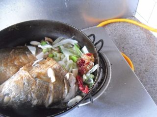 4、红烧大黄鱼,把煎好的鱼靠边，放入葱姜蒜、红辣椒爆香 
