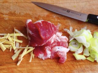 4、菠菜白玉菇虾皮汤,把猪肉用清水冲洗干净后用刀切成薄片,山东大葱用刀切成葱花,生姜切丝备用