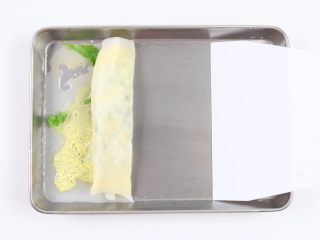 9、自制鸡蛋青菜肠粉,用刮刀从一边轻轻的卷起。