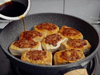 15、煎酿豆腐,将酱油、糖、两克盐、九克鲍鱼汁和半碗水加入碗里，调成酱汁，淋在豆腐上。