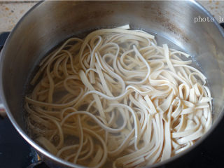 3、凉拌豆腐丝,锅中加入适量的清水烧开后放入豆腐丝煮一下。捞起来，滤干水份备用。