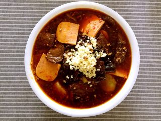 14、川味毛血旺,将煮好的食材倒入铺好豆芽的碗中，放入蒜末。