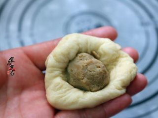 7、板栗馅柔软小餐包,取一个小面团，摁薄，包入馅料，搓圆