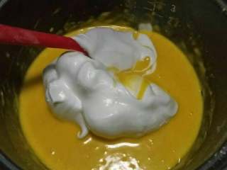 10、家庭烤箱自制戚风蛋糕,放入三分之一的蛋清，用翻拌的方法轻轻翻拌以免蛋白消泡，直到看不见白色蛋白。动作要快且轻。