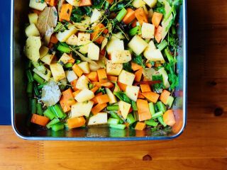 7、杂菜香草烤鸡腿肉,放入少许清水及2克盐,然后把煎好的鸡腿直接放在上面,加入红酒醋、白兰地、柠檬皮碎和半个柠檬的汁,小火煮两分钟。