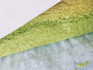 16、【网上厨房独家】丸久小山园名物蛋糕卷—复刻,晾晒网上铺烤纸，蛋糕片脱模倒置放在晾晒网上，撕掉底部的烤纸，再将上色一面翻到上面，轻轻盖上烤纸待温凉