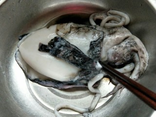 1、家宴-洋葱炒墨鱼,首先处理墨鱼，将那层黑皮剥掉。