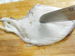 4、家宴-洋葱炒墨鱼,用刀尖划出十字花刀。先竖着划。