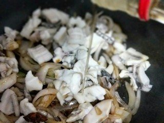 16、家宴-洋葱炒墨鱼,加入料酒。