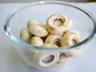 1、香酥烤蘑菇,把蘑菇洗净，沥水，拔去蘑菇根，备用