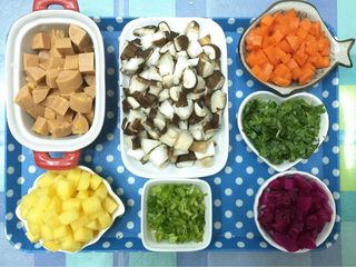 1、五彩扬州炒饭#健康美颜餐#,把新鲜蘑菇去蒂和胡萝卜一起浸泡洗净，切丁备用。香菜去根须洗净，切碎备用。菠萝、火龙果，玉米热狗肠切丁备用。