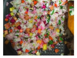 4、五彩扬州炒饭#健康美颜餐#,倒入红心火龙果粒、香菜碎翻炒1分钟，直至锅内食材拌炒均匀。加入适量食用盐和鸡精炒匀入味，即可出锅。