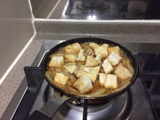 9、冻豆腐鸡蛋丼,再加入冻豆腐，煮开，用筷子翻动冻豆腐，让冻豆腐吸饱汤汁。