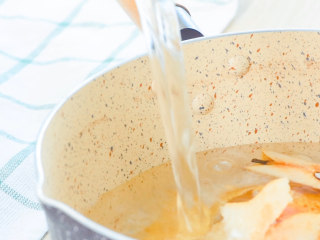 8、玫瑰圆子梨汤,梨皮和梨核，放入锅内，加水。