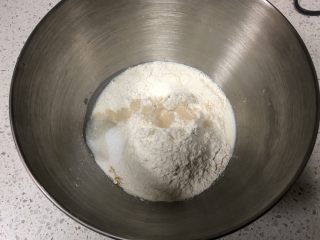 1、圣诞花环面包,厨师机面盆内先倒入牛奶、全蛋液，然后倒入高筋面粉，盐和糖对角线放置，中间挖一小孔倒入活性干酵母