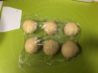 7、圣诞花环面包,取出面团按压排气，分割为等大的六份，盖上保鲜膜松弛15分钟