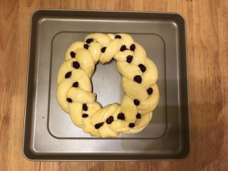 14、圣诞花环面包,发酵好的面团，刷上一层全蛋液，在辫子的交接处放上提前用朗姆酒泡好并吸干水分的蔓越莓干