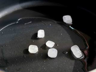 5、红烧肉炖白萝卜,锅内放入适量的色拉油，放入几块冰糖，不停的翻炒至变黄；