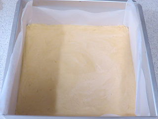 7、法式小甜点【椰蓉柠檬小方】,将面团放入铺了油纸的烤盘内。用手把面团压平