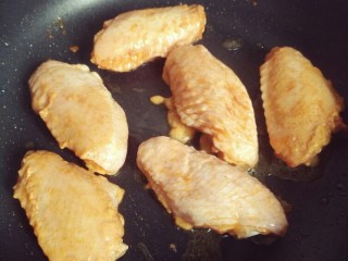 7、懒人版奥尔良中翅,鸡翅倒入锅里中火煎，煎鸡翅的过程中容易溅油，可以盖上锅盖，不时晃动下平底锅，防止糊锅