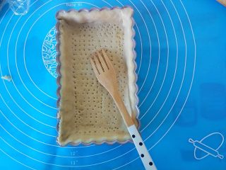 15、蜂蜜焦糖核桃派,用叉子把面皮叉出小孔，再在铺上锡纸压上重物170度上下火烤10分钟，面皮上色