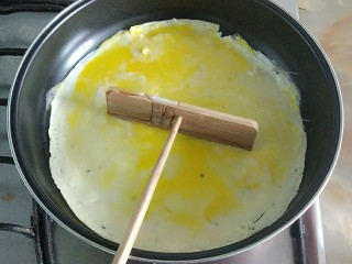 13、家庭版简易鸡蛋卷饼，双蛋青菜营养版,用竹蜻蜓把鸡蛋铺匀。