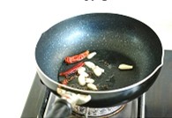 5、果醋拌木耳,锅里油热后,放入花椒、蒜片和干红辣椒,炸至蒜片变黄即可。