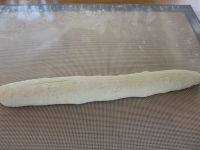 11、酥皮法棍面包,取一份，轻轻地拍出空气，翻面；将下边卷到中间，按合；再将上面翻过来；再翻过去，拍出空气；再翻下来，搓成长条法棍状