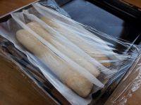 12、酥皮法棍面包,依次做好另外两个，放在烤纸上，烤纸中间折叠成隔断，蒙上保鲜膜