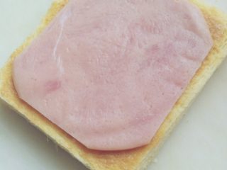 4、芝士火腿西多士,将火腿片放上（另一片同此步骤）