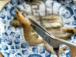 2、#春节家宴#-面条缠虾,再用食品剪刀把虾的爪子剪掉，依次做完。