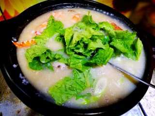 16、家庭简易版螃蟹海鲜粥,粥煮沸，大约五分钟，海鲜也已经全熟了，倒数滴味极鲜，放入葱花，姜末，小青菜，三十秒关火。