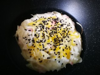 12、#圆土豆#培根土豆丝煎饼,蛋液铺平，撒上黑芝麻。