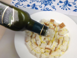 2、奶油蘑菇汤,将适量的橄榄油均匀的倒在切好的面包上