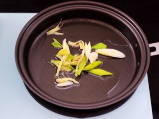 9、辣爆猪肝,早餐机的煎锅里倒入花生油烧热后,先爆香蒜苗和姜丝。