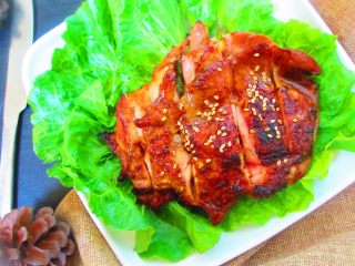 11、碳烤鸡腿肉,把生菜扑在盘子里，放上烤好的鸡腿，用刀切开，撒上白芝麻即可开吃