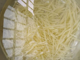 4、这道菜成本就几块钱，比大鱼大肉还好吃！,将切好的土豆丝放入冷水中浸泡，（这一步是将土豆丝表面的淀粉充分洗净。这样后面炒的时候就不会因为淀粉粘锅）