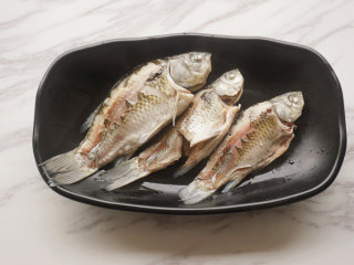 1、热拌鲫鱼,将大蒜、老姜切碎；小米辣剁碎；葱切成花；香菜切碎待用