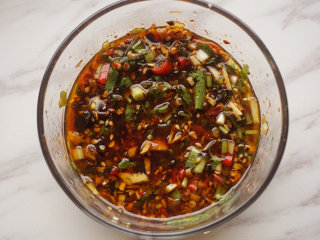 3、热拌鲫鱼,将小米辣、香菜碎、葱花、蒜末、姜米、酱油、鲜辣露、红油、花椒油、陈醋、香油、盐拌匀成汁儿待用