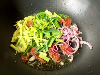 10、快手香肠炒意面,放入芹菜、洋葱、蒜苗翻炒片刻。