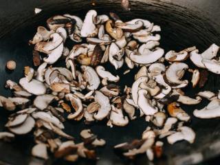 4、焦糖酱油面,在锅中加入勺油,加入蘑菇。