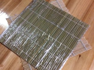 2、家庭寿司——三文鱼手握和细卷,给寿司帘上保鲜膜，方便卷三文鱼细卷