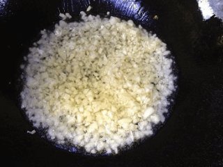 4、蒜蓉粉丝开片虾 ,蒜头去皮,压碎剁蒜末,炒锅中放少许油,中火加热后倒入蒜末,炒至微黄关火;